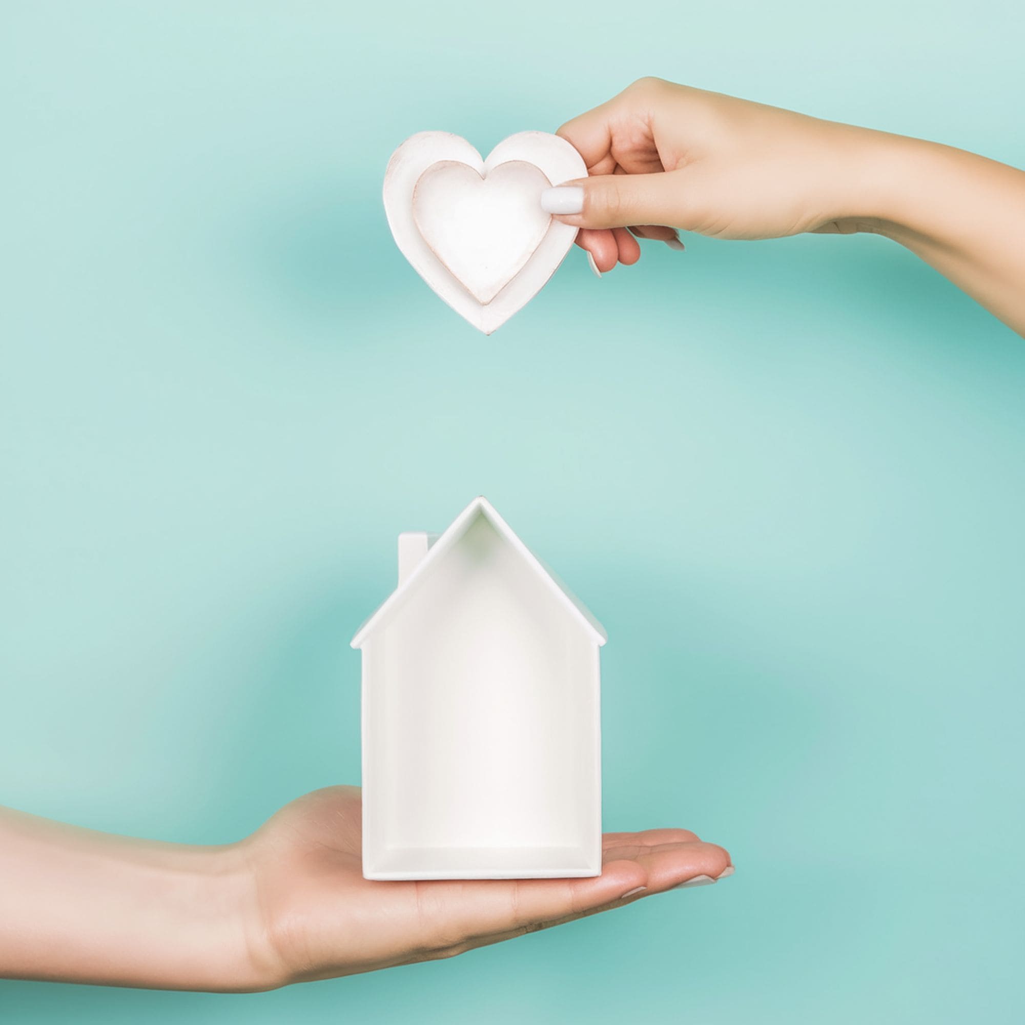 Hands Holding a Small White House and Heart